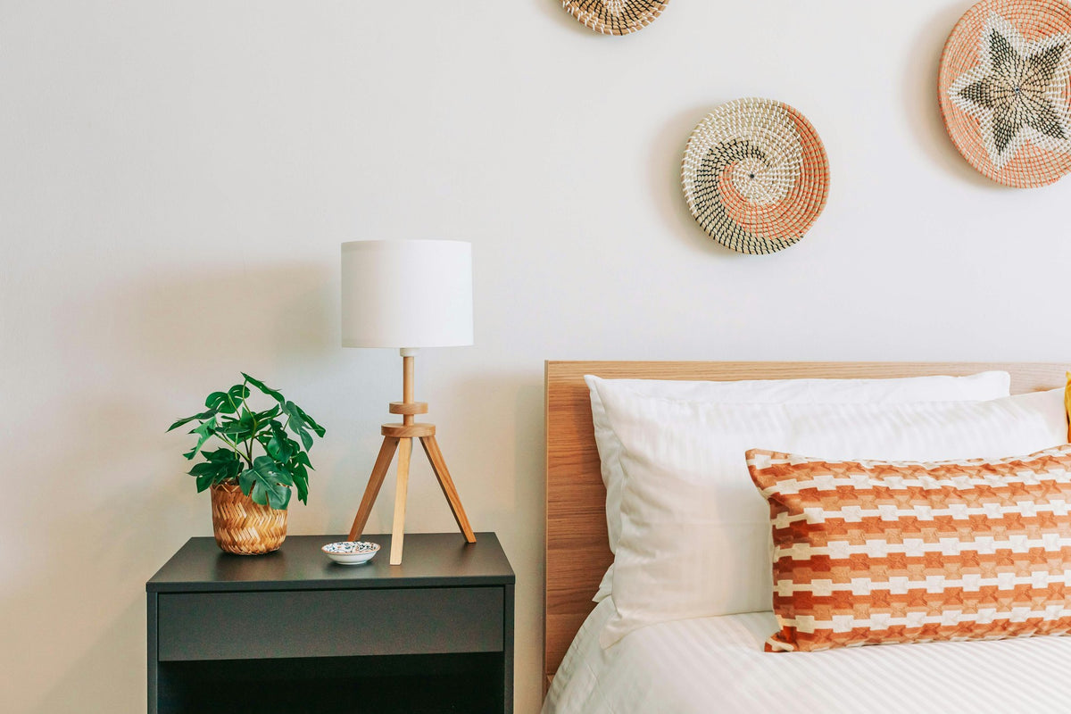 Bright bedroom with a small potted plant beside the bed